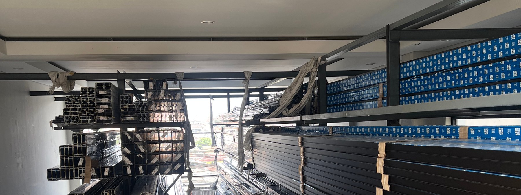 Rak stok profil aluminium di gudang Crystal Aluminium